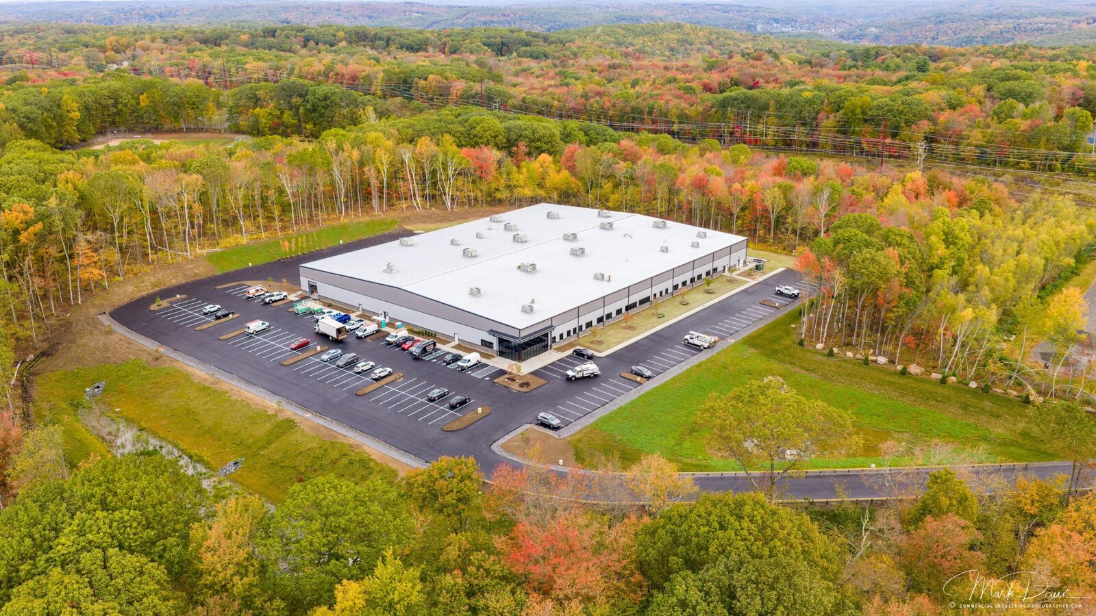 Aerial drone photograph of a manufacturing facility surrounded by fall foliage