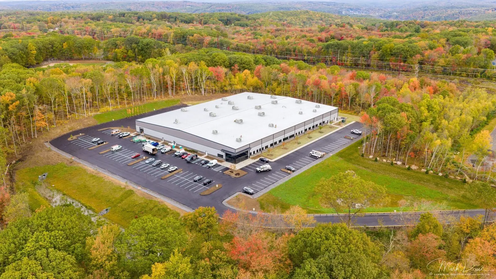 Aerial drone photograph of a manufacturing facility surrounded by fall foliage