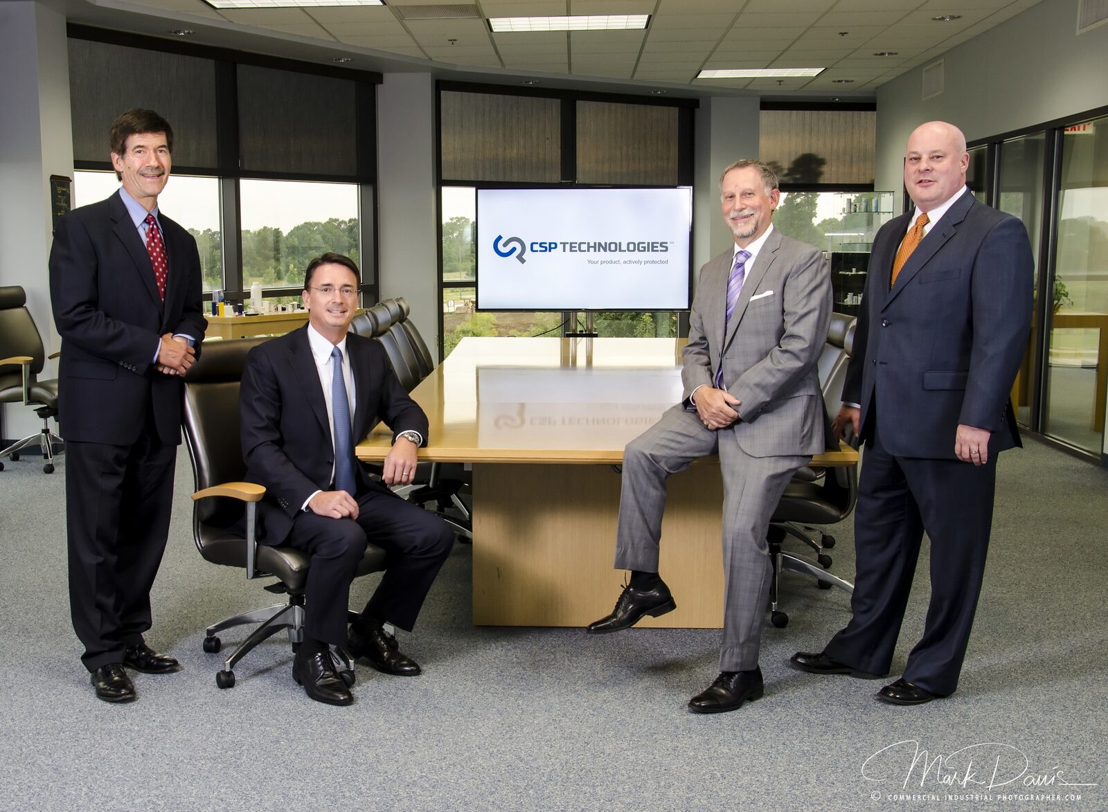 Group of corporate executives photographed around a conference room table
