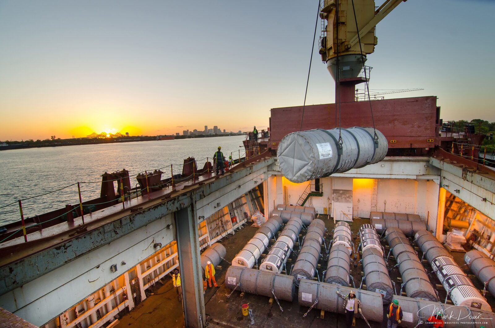 Crane loading cargo onto a vessel at the Port of New Orleans at sunset
